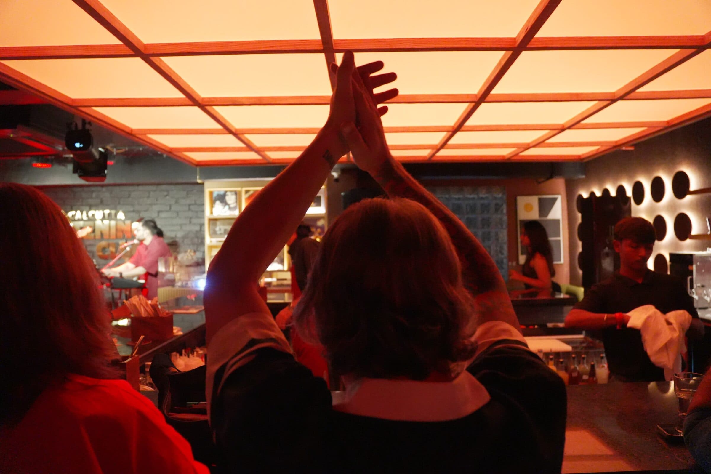 A guest applauding under the orange ceiling